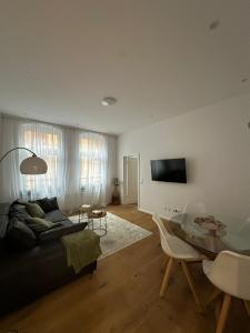 a living room with a black couch and a glass table at Nook - Zentrale Lage - an der ListerMeile in Hannover