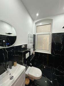 a black and white bathroom with a toilet and a sink at Nook - Zentrale Lage - an der ListerMeile in Hannover