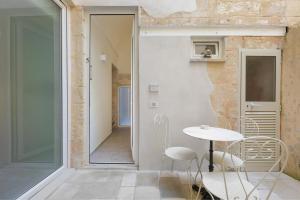 a room with a table and chairs next to a door at Liberty Barocco in Lecce +7 photos