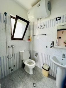 a bathroom with a toilet and a sink at Vila Toskaj in Vlorë