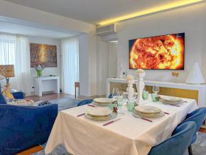 a dining room with a white table and blue chairs at Suite al Castello Boccale Terrazza sul Mare in Livorno +57 photos