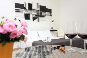 a room with a bed and two glasses of wine at Il Piccolo Principe in Alghero