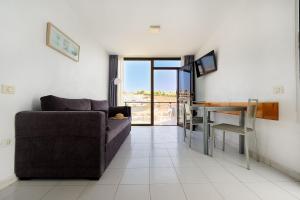 una sala de estar con un sofá y una mesa en Ura Roslara, en Puerto Rico de Gran Canaria