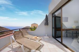 Un balcón con una silla y vistas al océano. en Ura Roslara, en Puerto Rico de Gran Canaria