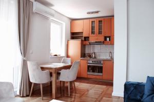 a kitchen with a table and chairs and a refrigerator at PARK Apartment in Bijeljina