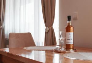 a bottle of wine sitting on a table with a wine glass at PARK Apartment in Bijeljina +14 photos