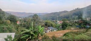 a view of a village with mountains in the background at NectorNest in Kodaikānāl
