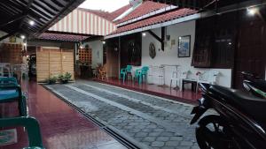 a building with a patio with chairs and tables at Fortuna Guest House in Yogyakarta