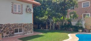 a yard with a swimming pool next to a house at Habitación,Piscina y Jardín in Azuqueca de Henares