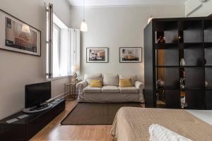 a living room with a couch and a television at Well-Located Studio with Smart Space in Lisbon