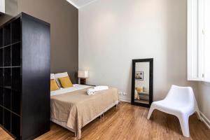a bedroom with a bed and a chair and a mirror at Well-Located Studio with Smart Space in Lisbon