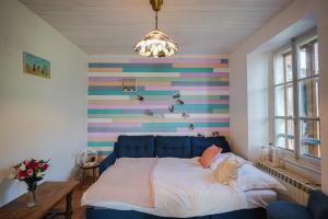 a bed in a room with a colorful striped wall at Le Nid D'Hauteluce - Proche centre ville in Hauteluce