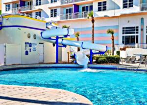 a water slide in a pool in a resort at 14th Floor 2 BR Resort Condo Direct Oceanfront Wyndham Ocean Walk Resort Daytona Beach 1401 in Daytona Beach