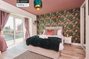 a bedroom with a large bed with a floral wallpaper at Spacious 4BDR House By Homebird Property Management Short Lets & Serviced Accommodation Leeds With Private Parking & Garden in Leeds
