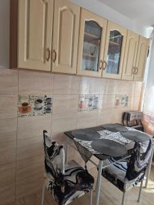 a kitchen with a table and chairs and cabinets at Bogdan my sun in Galaţi