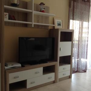 sala de estar con TV y centro de entretenimiento de madera en Benidorm La Cala Sidney, en Cala de Finestrat