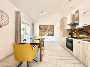 a kitchen with a wooden table and yellow chairs at Apartments Villa A - Heating Pool in Trogir