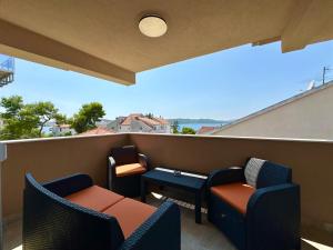 a balcony with chairs and a table with a view at Apartments Villa A - Heating Pool in Trogir