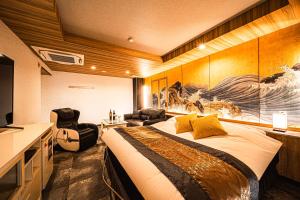 a hotel room with a large bed and a television at Hotel M in Oyodo