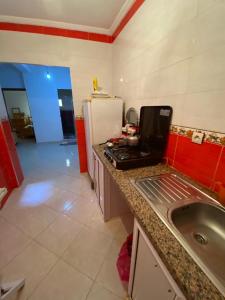 eine Küche mit einem Laptop auf einer Theke neben einem Waschbecken in der Unterkunft Morocco,Tetouan,Martil in Martil