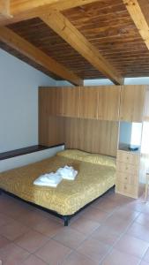 a bed in a room with a wooden ceiling at Residence Albachiara in Marina di Camerota