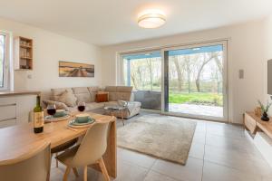 a living room with a table and a couch at Füzliget Gardenlight in Balatonfůzfő