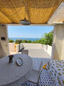 a patio with a table and chairs and a view of the ocean at Circe in Capo Vaticano
