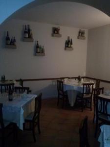 a dining room with tables and chairs with bottles on the wall at La Collinetta sas in Montazzoli +31 photos