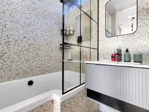 a bathroom with a tub and a sink and a mirror at Cute Kloof Street Studio in Cape Town +13 photos