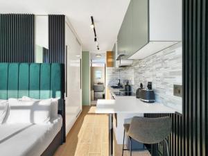 a room with a bed and a kitchen with a table at Cute Kloof Street Studio in Cape Town