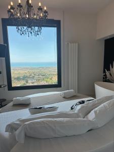 a bedroom with a bed with a large window at Vista Templi Luxury Suite in Agrigento