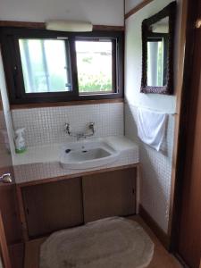 a small bathroom with a sink and two windows at 大黒様ハウス in Hokuto +5 photos