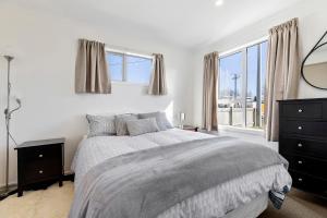 ein weißes Schlafzimmer mit einem Bett und einem Fenster in der Unterkunft Large Family Lakehouse in Mangakino