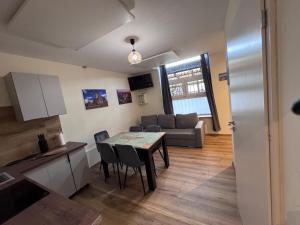 a kitchen and living room with a table and a couch at Na Alei in Janowice Wielkie