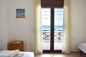 a bedroom with a door with a view of the ocean at Beachfront Bliss in Nikiti, Spacious 2 Story Villa with Stunning Sea Views in Skála Nikíta