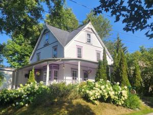 a white house with a purple at Ô Bois Dormant B&B in Magog-Orford