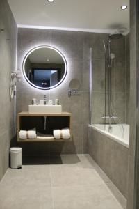 a bathroom with a sink and a shower and a mirror at Hôtel Les Muses in Annecy +69 photos