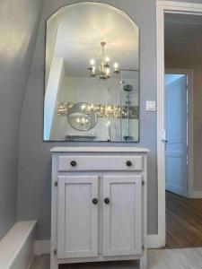 a white dresser with a mirror on top of it at maison de charme au coeur de la baie de somme in Noyelles-sur-Mer