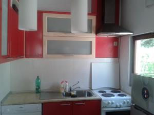 a small kitchen with red cabinets and a sink at Apartment Sasha in Kotor