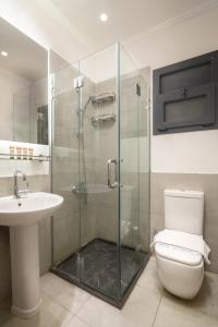 a bathroom with a shower and a toilet and a sink at Ios Hotel & Village Extension in El Alamein