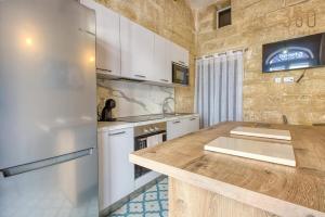 a kitchen with a wooden counter and a refrigerator at Stylish Townhouse with Balcony next to Waterfront by 360 Estates in Senglea
