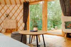 a room with a bed and a table and a window at Jurta v pastvinách in Trutnov +6 photos