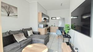 a living room with a couch and a table at Urban Oasis in Boksburg +7 photos