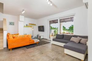 Una sala de estar con dos sofás y un televisor. en Villa Rosalija, en Kirmenjak