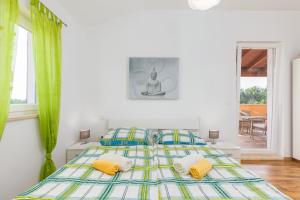 Dormitorio blanco con cama con almohadas amarillas y azules en Villa Rosalija, en Kirmenjak 47 fotos más