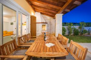 Una mesa y sillas de madera en un patio. en Villa Rosalija, en Kirmenjak