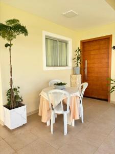 a table and chairs in a patio with a potted tree at Casa em Condomínio in Brasilia
