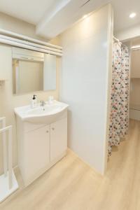 a white bathroom with a sink and a mirror at Studio palais des festivals Croisette in Cannes