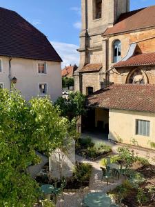 a courtyard with chairs and a building with a tower at Le Prieuré d'Arbois in Arbois