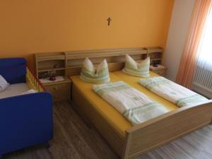 a bedroom with a wooden bed with pillows on it at Ferienwohnung-Haus-Wannenberg in Tengen